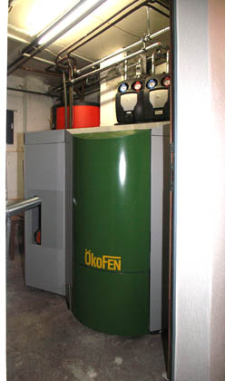 Pellet-Kessel Oekofen, 24 kW mit Direkteintragung (Schnecke) und Boiler im Hintergrund 